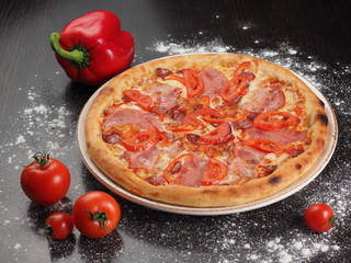Pizza with sausage, tomatoes and cheese on a plate