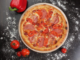 Pizza with sausage, tomatoes and cheese on a plate