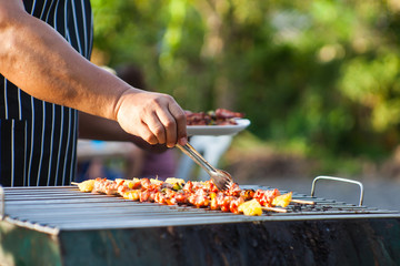 Close-up shots of a man doing a barbecue To wait for friends to come to the party this evening