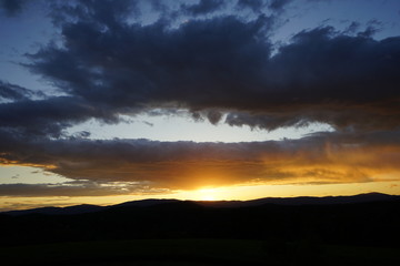 Fototapeta premium Brilliant Sunset with Clouds Over Mountains