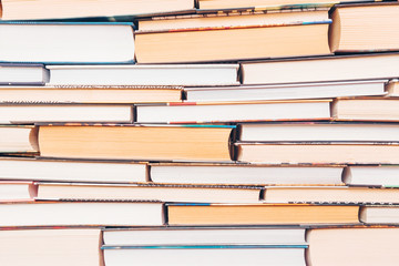 Background of books - several books lie on top of each other. White and yellowish pages. Concept of learning, education, reading, libraries, beginning of the school year, the acquisition of knowledge.