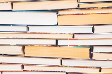 Background of books - several books lie on top of each other. White and yellowish pages. Concept of...