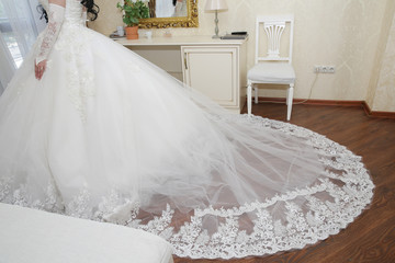 Fototapeta na wymiar bride in a white wedding dress with lace and a long train
