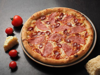 Pizza with sausage, sausages and cheese on a plate