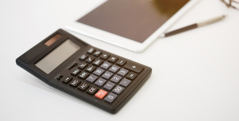 close up  calculator with tablet and pen on white table for business financial concept