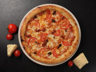 Pizza with tomatoes and cheese on a plate
