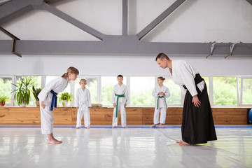 Girl giving a bow to trainer before practicing aikido