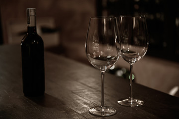 Two wine glass with wine bottle on wood bar