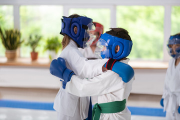 Boy and girl wearing protective helmets practicing fight