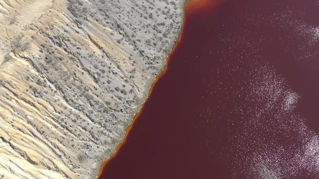 Red water containing metals from mine wastes 4K aerial video