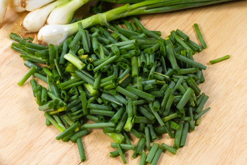chopped of fresh scallion or spring onions on wooden board