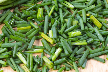 chopped of fresh scallion or spring onions on wooden board