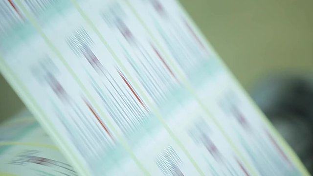 Metal White Label Printing Rolls with High speed labeling machine in industrial factory, sticker on product in manufacture. Flexible packaging. Tilt Down Macro with bokeh.