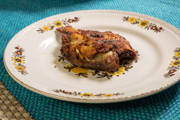 Fried pomfret fish served on a platter,