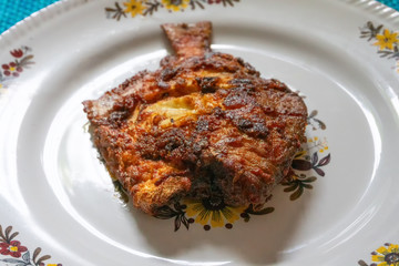 Fried pomfret fish served on a platter,