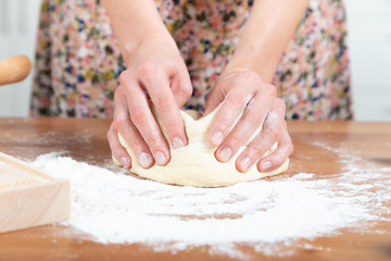 Young beautiful girl making dough