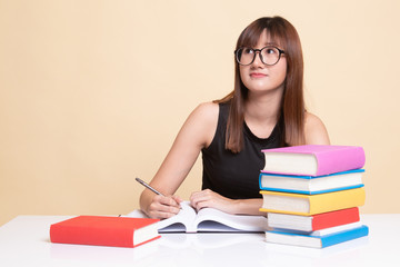 Young Asian woman read a book with books on table.