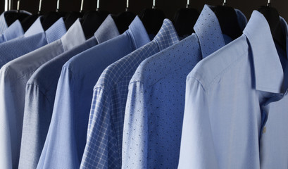 Man's classical shirts hanging in a row