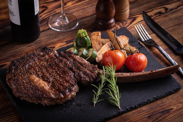 Fototapeta grilled tomahawk ribeye steak on black stone plate obraz