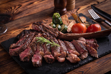 grilled tomahawk ribeye steak on black stone plate