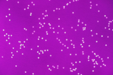 Bunch of silver stars on violet background.