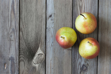 Three pears on a natural wooden background. Copy space