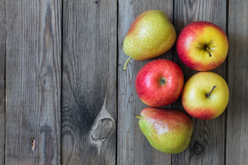 Juicy apples and pears lying on a natural wooden table. Copy space