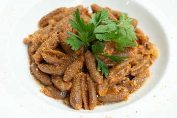 close up of traditional orecchiette pork pasta in a white plate isolated