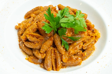close up of traditional orecchiette pork pasta in a white plate isolated
