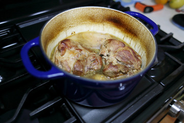 Pork roast cooked in a Dutch oven resting on the stove top.