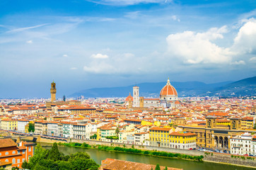 Fototapeta na wymiar Top aerial panoramic view of Florence city with Duomo Cattedrale di Santa Maria del Fiore cathedral, buildings houses with orange red tiled roofs and Arno river, blue sky white clouds, Tuscany, Italy