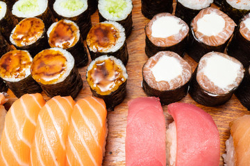 several sushi and rolls on wooden board
