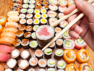 chopsticks with tuna roll over assortment of sushi
