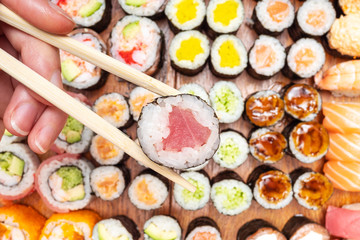 top view of chopsticks with roll over many sushi