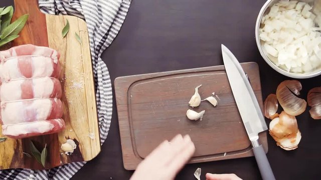 Flat lay. Step by step. Dicing organic garlic on wood cutting board.
