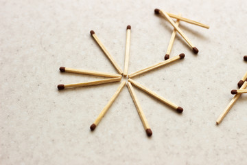 Matches scattered around on a table - concept of security. Unused matches on white surface. Matches the shape of the sun. Used matches. Used matches on white surface