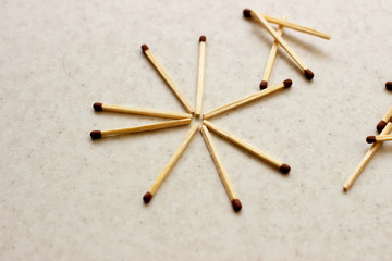 Matches scattered around on a table - concept of security. Unused matches on white surface. Matches the shape of the sun. Used matches. Used matches on white surface