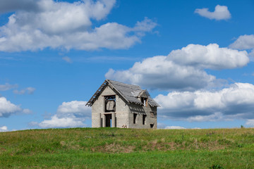 unfinished house on the green field against blue sky