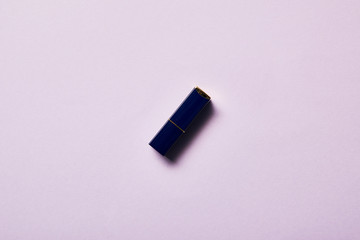 top view of one tube of lipstick on purple