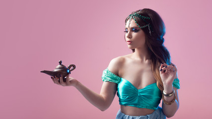 Oriental fairy tale, a young Princess woman with a magic lamp in her hands.