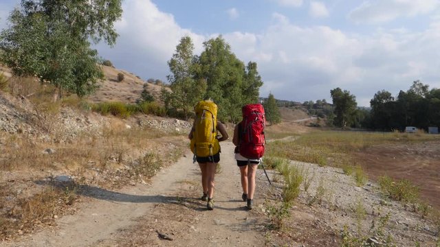 Slow motion footage following two female backpackers on a trail
