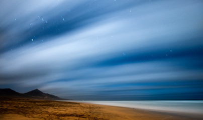 Fototapeta na wymiar Night picture with long exposure and night star in movement - beach and mountains beautiful wild landscape for travel adventurer and alternative vacation feeling the nature