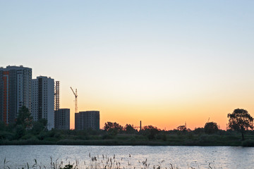 Obraz premium Sunset or sunrise in the city. Modern residential district near the pond of Saint Petersburg, Russia, Kupchino.