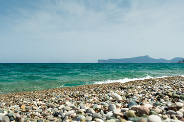 Fototapeta na wymiar Pebble beach with sea waves. Travel concept. Selective focus