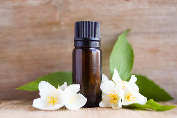 Spa perfume essential aroma oil glass bottle with flower blossoms on old wooden background