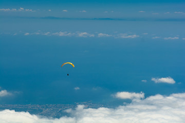 Paragliding flying in the sky over mountains and sea. Aerial view from Tahtali mountain, Turkey. Extreme sport or travel concept