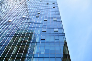 Bottom view of modern skyscrapers in business district against blue sky