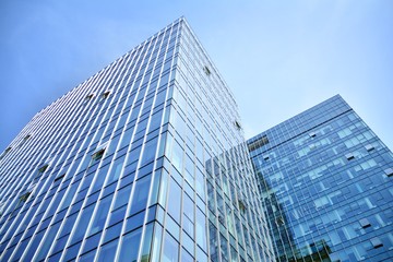 Fototapeta na wymiar Bottom view of modern skyscrapers in business district against blue sky