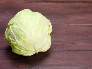 Green cabbage on a brown wooden background