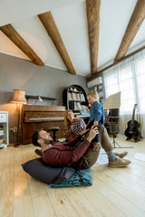 Happy young family playing on the floor at rustic room